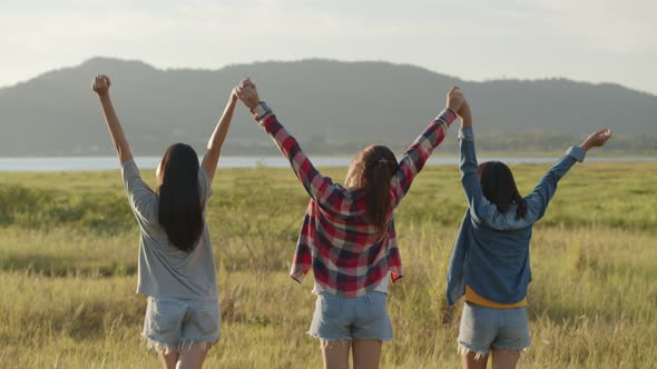 Group of a young Asian woman holding hands walking having fun together a summer traveling.