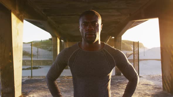 Portrait of focused african american man looking at camera, exercising outdoors in the evening