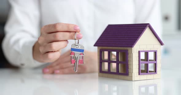 Realtor Shows Model of House and Keys