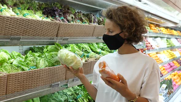 A Woman in a Face Mask Comparing Carefully Pre Packed Vegetables and Chooses the Best Ones