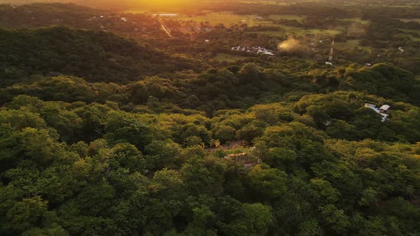 Fast aerial orbit around a private property sitting on a mountain ridge within the coastal rainfores