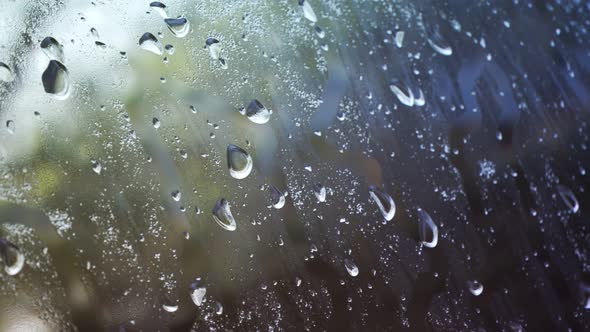 Camera moving slowly next to a window full of water droplets and condensation.