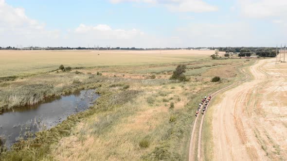 Cyclists riding on gravel bicycles on trail road in countryside.