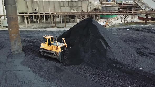 Bulldozer sorts coal. Extractive industry, anthracite. Coal industry.