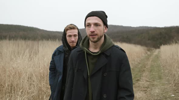 Two Friends Walking On The Road In The Field. They Jokingly Fight.