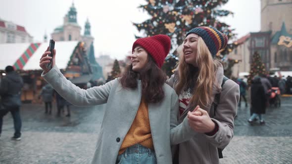 Portrait of Two Girls Making Selfie in Center of Square in European Town