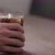 Slow Motion Man Hand Take Cola in Tumbler Glass with Ice From Walnut Table with Copy Space - VideoHive Item for Sale
