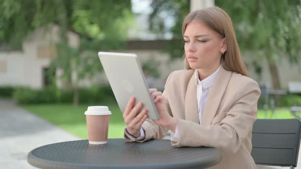 Attractive Young Businesswoman Using Tablet in Outdoor Cafe