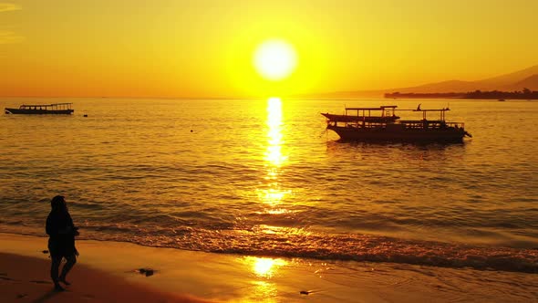 Woman Taking A Peaceful And Relaxing Walk On The Beach Of The Bahamas With The Orange Setting Sun In