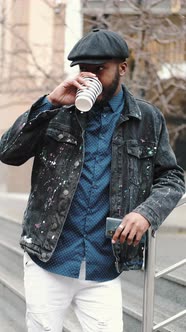 Stylish African Young Man Outside with His Smartphone