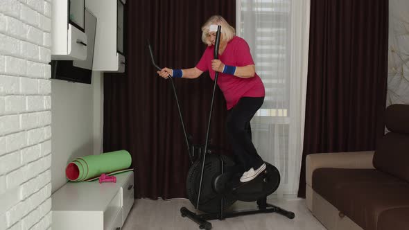 Senior Woman in Sportswear Using Orbitrek in Room at Home Doing Sport Training Cardio Exercises