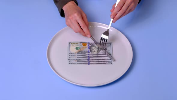Hands Try to Eat a Dollar Bill on the Plate Using Cutlery  Video