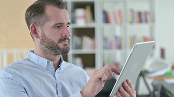 Portrait of Focused Young Man Using Digital Tablet