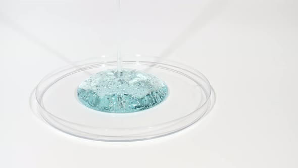 Transparent Cosmetic Gel Fluid Dripping Into the Glass Bowl of Petri