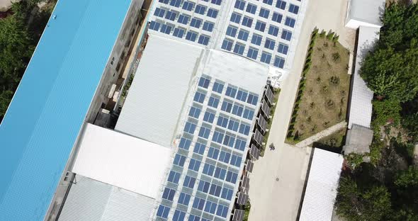 Drone Flying Over Rooftop Solar Installation On Office Warehouse Space