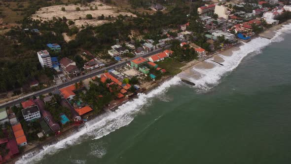 Ocean water almost hitting Vietnamese town. Beach erosion problem. Aerial drone view