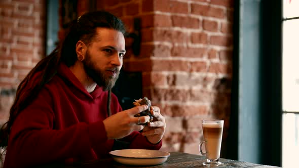 Hungry Guy is Having Lunch in Cafe Eating Tasty Juicy Burger in Fast Food Restaurant American