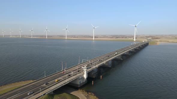 Drone flying along bascule brigde, windmill riverbank landscape, Ketelbrug Bridge