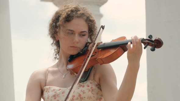 young curly blond woman the violinist: Musician playing violin