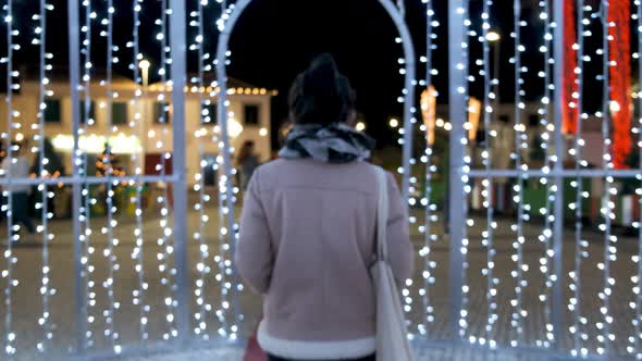 Shot from behind woman walk out of focus on Christmas Light decoration Frame