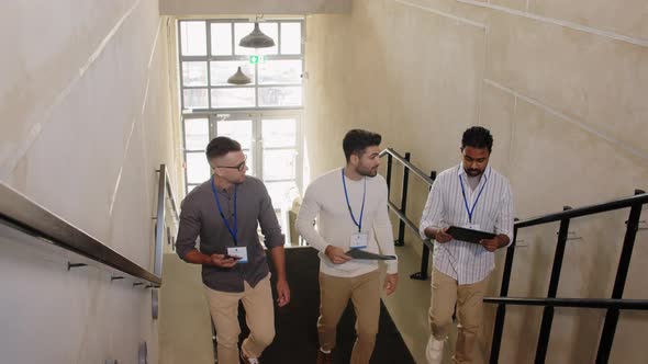 Businessmen with Name Tags Walking Upstairs