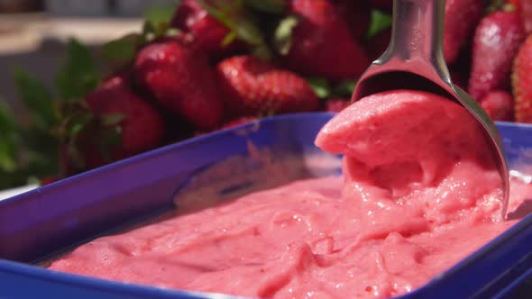 Closeup of the Special Spoon Scooping a Fresh Cold Strawberry Icecream