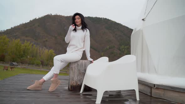 Beautiful Girl with Black Hair in Glasses in White Clothes Backdrop of Mountains