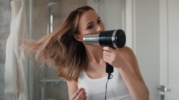 Caucasian woman drying hair in the bathroom. Shot with RED helium camera in 8K.