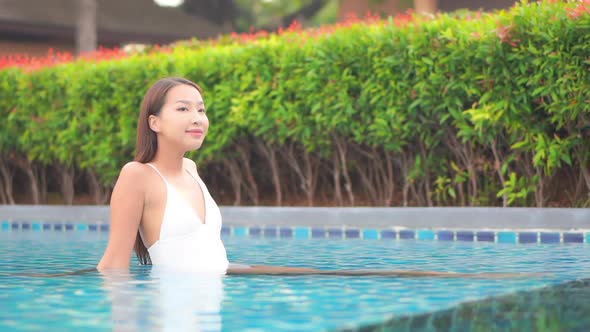 Young asian woman enjoy around outdoor swimming pool for leisure