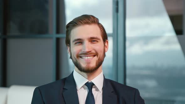 Young businessman smiling and looking at camera. Young man in the office