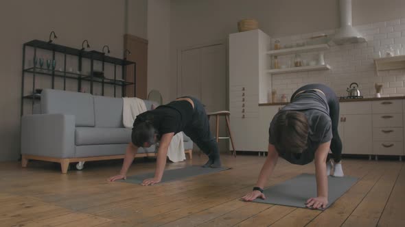 Man and Woman Practicing Yoga at home