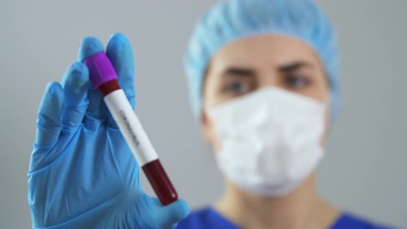 Doctor Holding Beaker with Coronavirus Blood Test