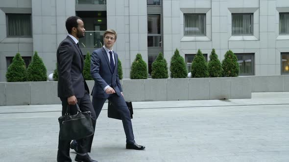 Businessmen Talking Outdoors, New Employee Trying to Make Friends With Coworker