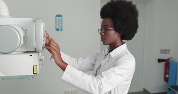 In the Hospital Man Lying on a Bed Female Technician Adjusts XRay Machine