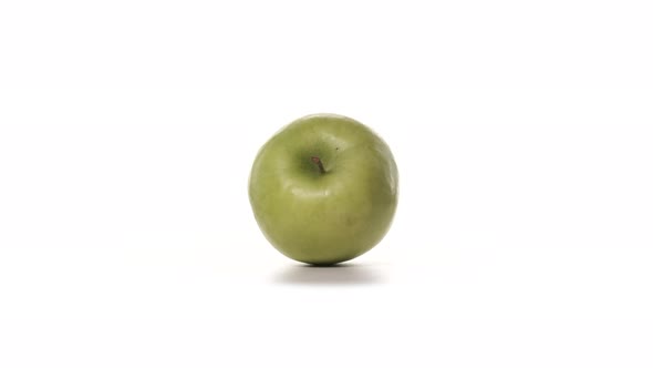 One Fresh Green Apple is Spinning on White Background