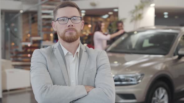 Portrait of Successful Caucasian Car Dealer Crossing Arms and Gesturing Yes By Shaking Head