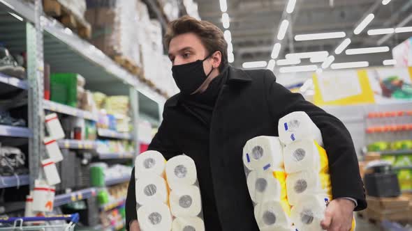 Man Walking in Medical Mask with Toilet Paper Shopping Bags During the Quarantine Coronavirus