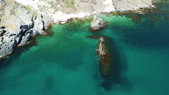 Aerial View From Above on Calm Azure Sea and Volcanic Rocky Shores