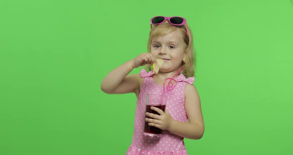 Child in Pink Swimsuit Drinks Juice Cocktail with Drinking Straw. Chroma Key