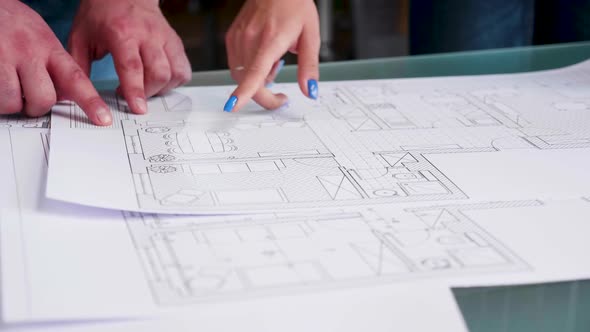 Close Up Hands of Architects Pointing on Blueprints