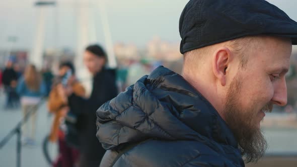 Portrait of a Blueeyed Bearded Man in a Cap Listening to Music