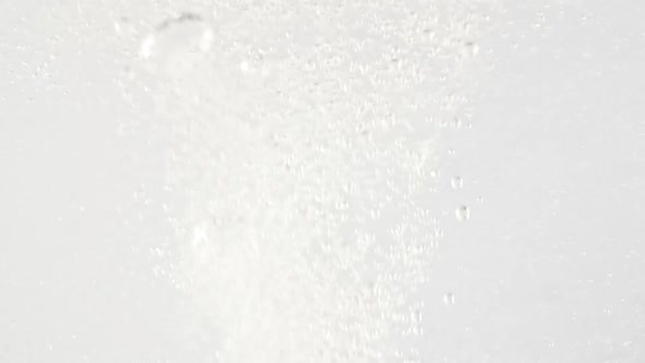 Macro Shot of Fine Air Bubbles Rising in Water on White Background