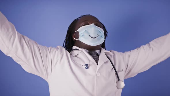Dancing African Doctor in Face Mask with Smile on Isolated on Blue Studio Background