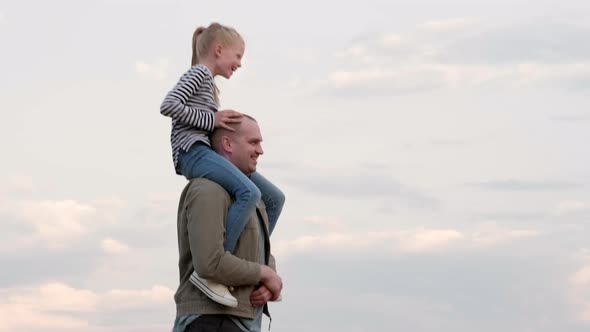 Young Dad Gaily Spending Time with Daughter Playing Together Outdoors on Summer