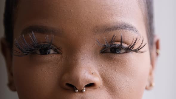 Closeup African Woman with Long Eyelashes Makeup Looking at Camera Happy with Cosmetic Procedure