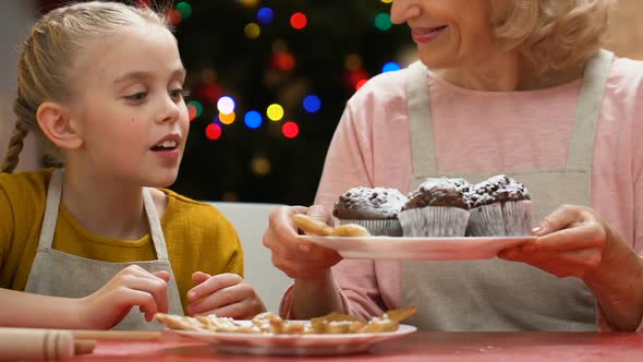 Girl Blowing Sugar Powder From Cupcakes, Laughing With Granny, Fun Together