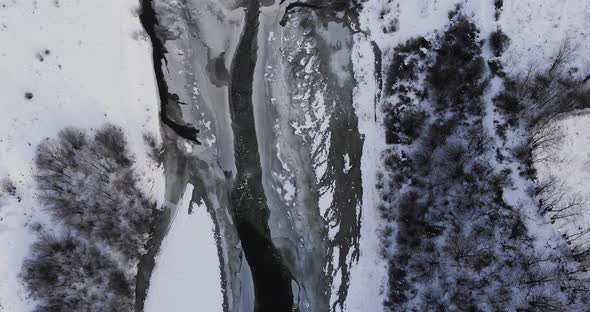 Long Narrow Road Over Frozen River Through Winter Forest Mountains - Aerial Drone Shot, Reveal
