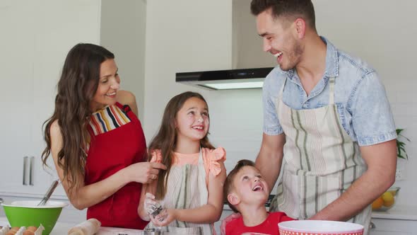 Happy caucasian family baking together, preparing cookies in kitchen