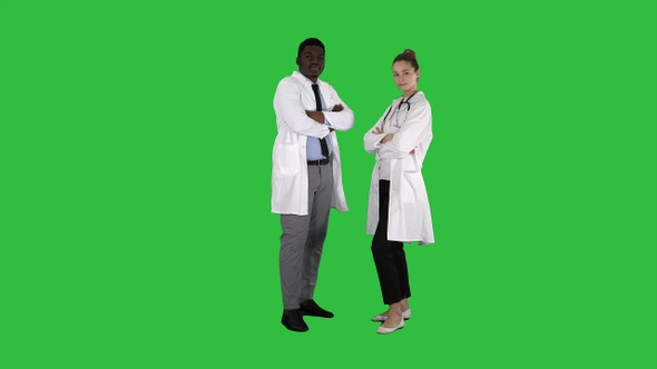 Woman and man doctors with crossed arms on a Green Screen