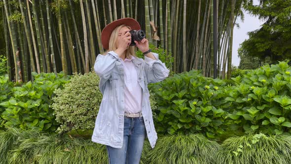 Photographer Takes a Pictures on a Camera in the Garden